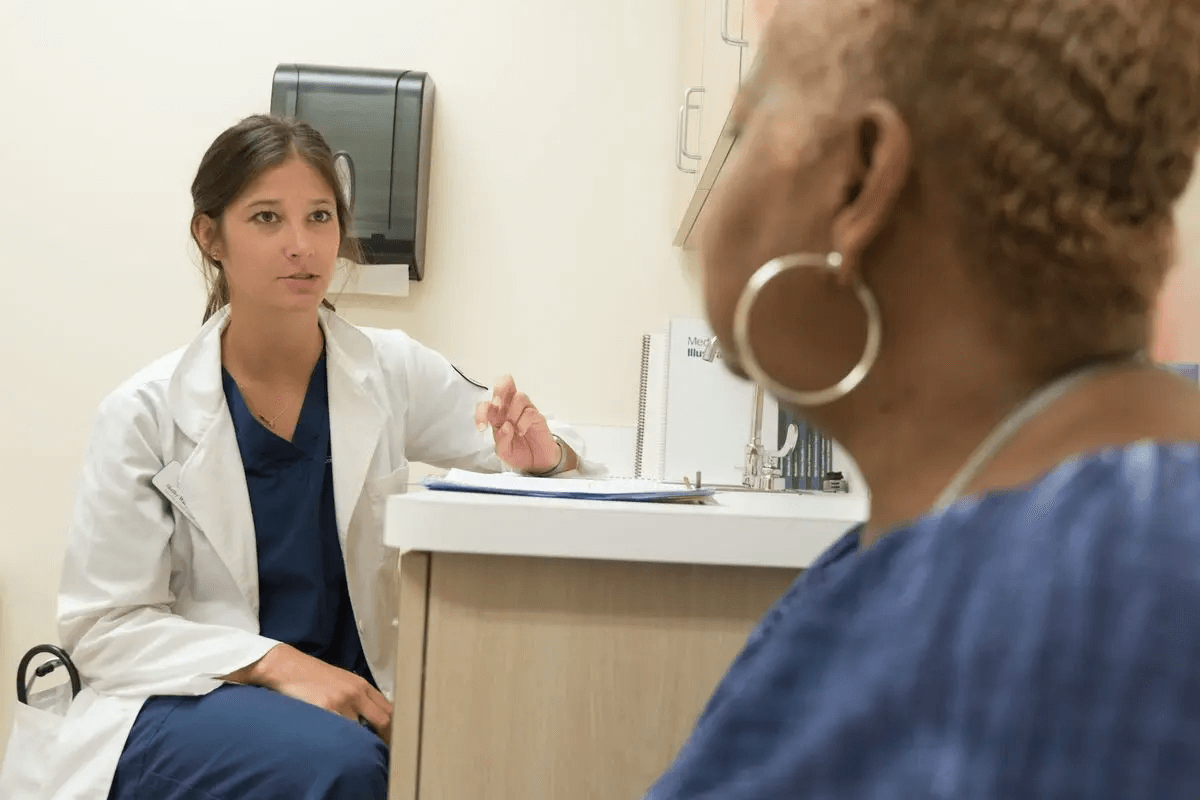 A woman physician speaks to a woman patient, an important step of efficient linguistic validation.