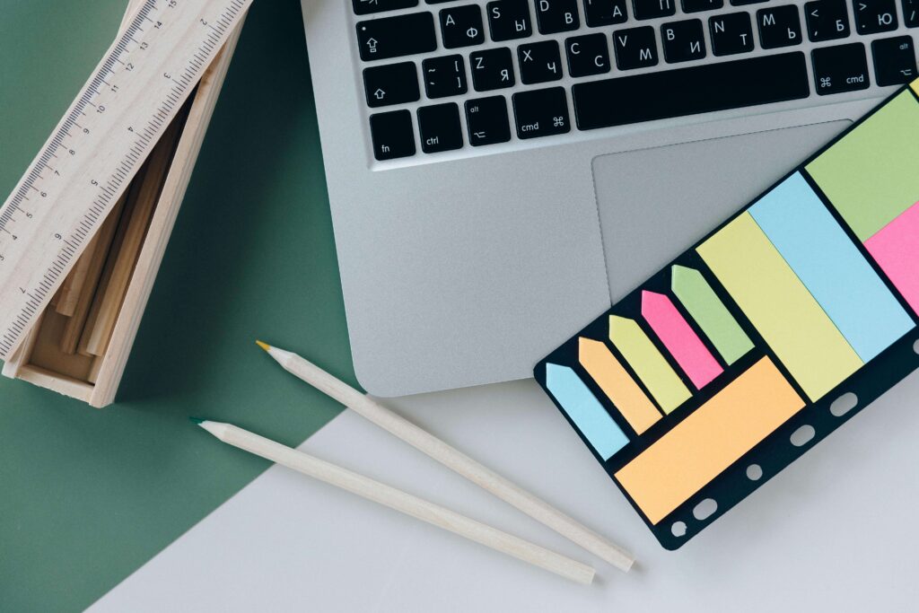 A laptop, colorful Post-its, pencils, and a blank page form a layout for a planning session of accessible medical devices.