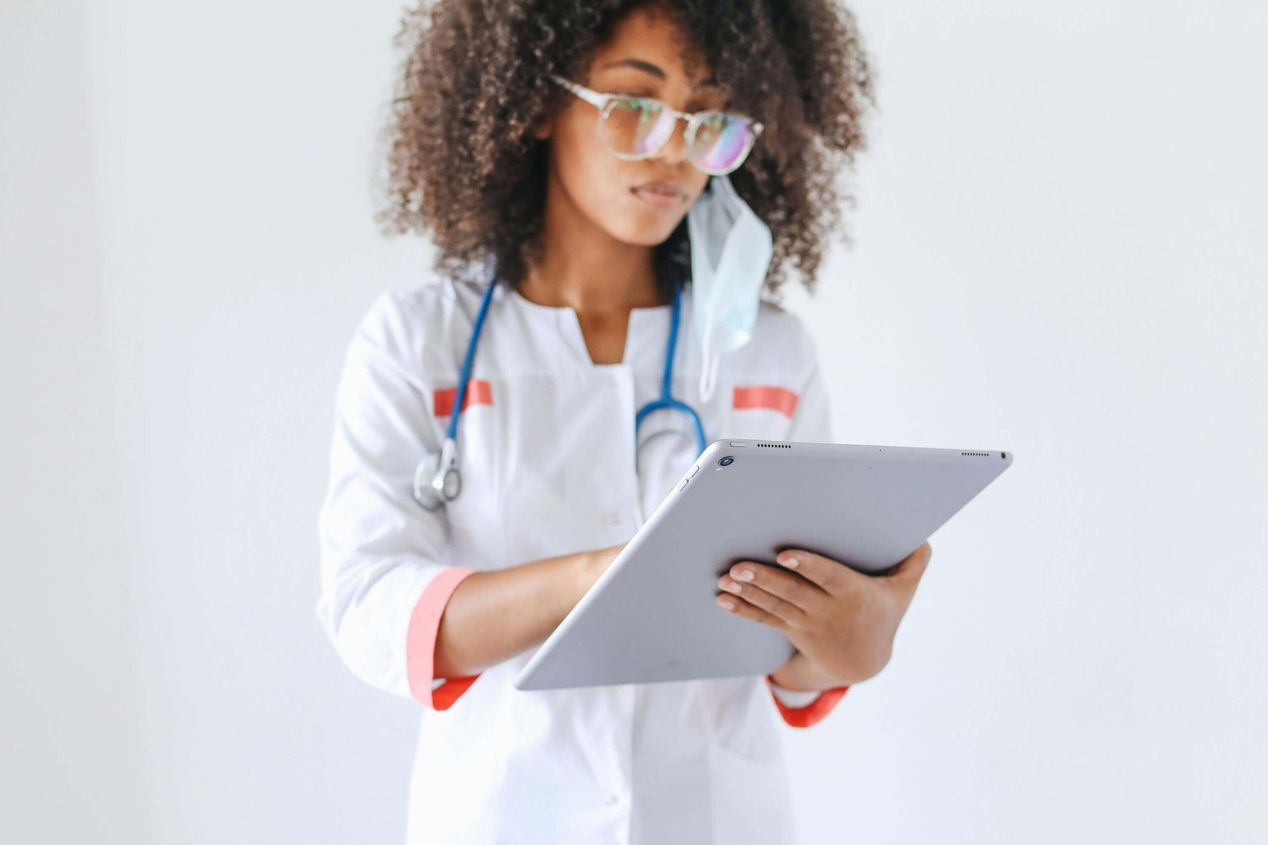 A woman doctor using an electronic device to navigate through clinical research data.